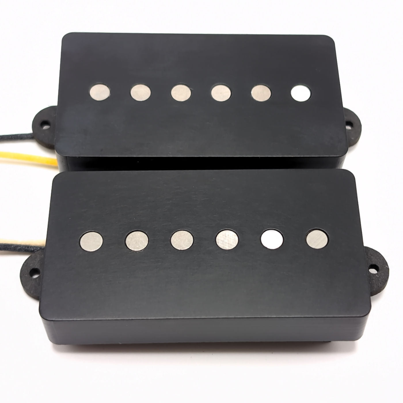 Two humbucker sized single coil pickups with black corian covers