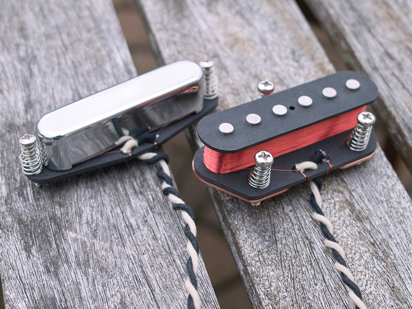 Neck and bridge pickup for Tele with black bobbins, chrome cover, and exposed red coil.