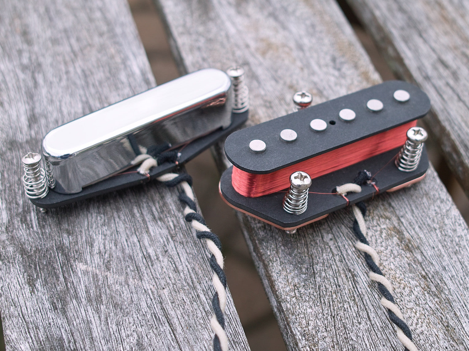 Neck and bridge pickup for Tele with black bobbins and chrome cover. The bridge coil is exposed to show the magnet wire.