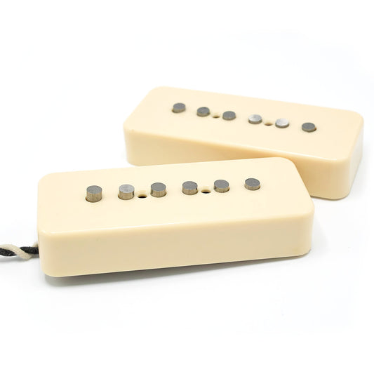 Two soapbar style pickups with alnico rod poles and ivory covers.