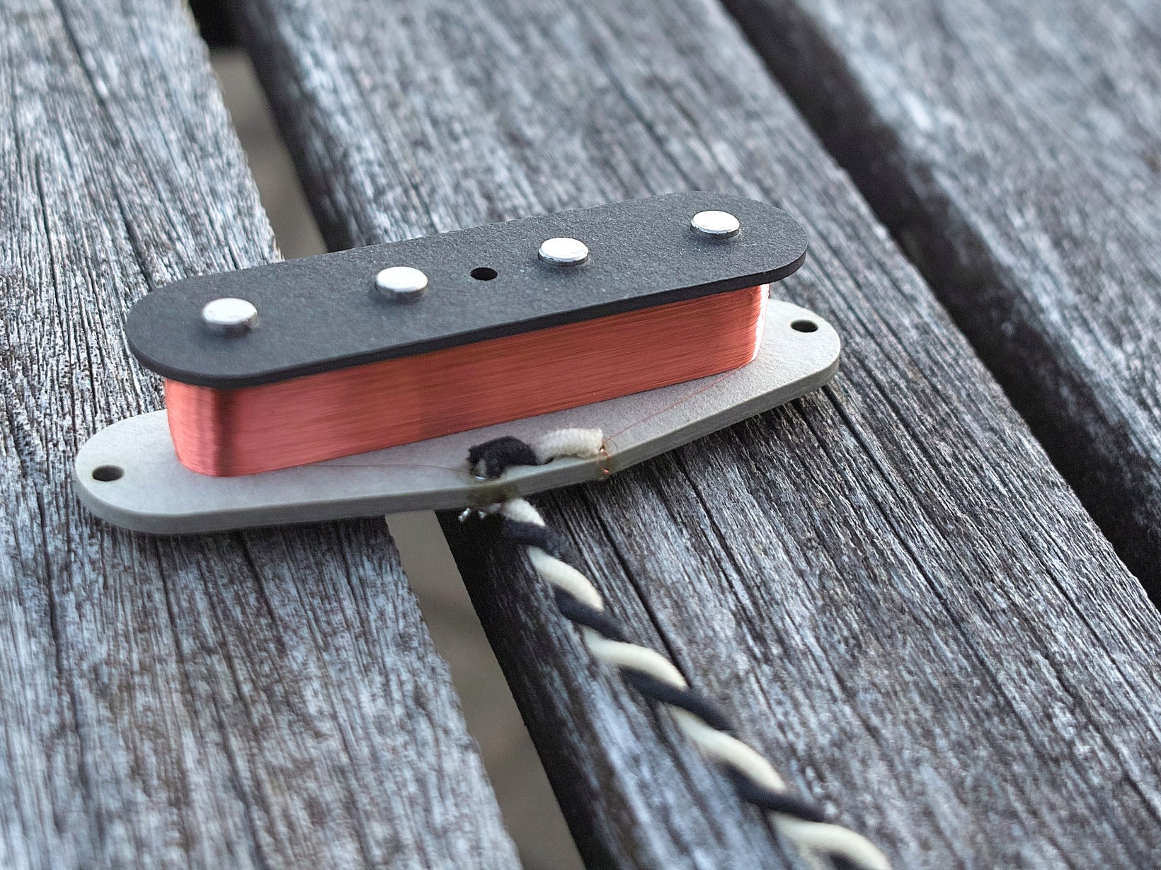 A single coil for 51 Precision Bass. It shows black and white lead wires.