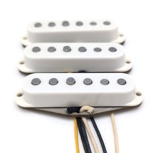 Three pickups for Stratocaster electric guitars with vintage staggered poles and parchment covers